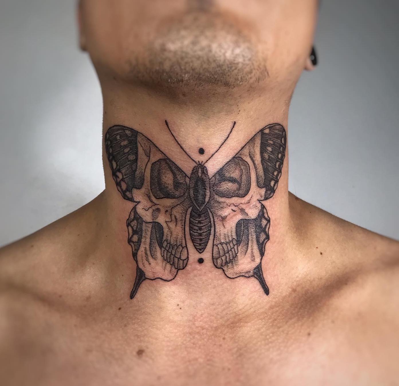 Butterfly skull neck tattoo